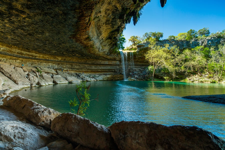 Hamilton Pool in Dripping Springs: A scenic natural swimming pool in a canyon below a 50-ft waterfall, surrounded by a grotto.