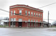 An old bank building with a corner entrance in Venus, Texas