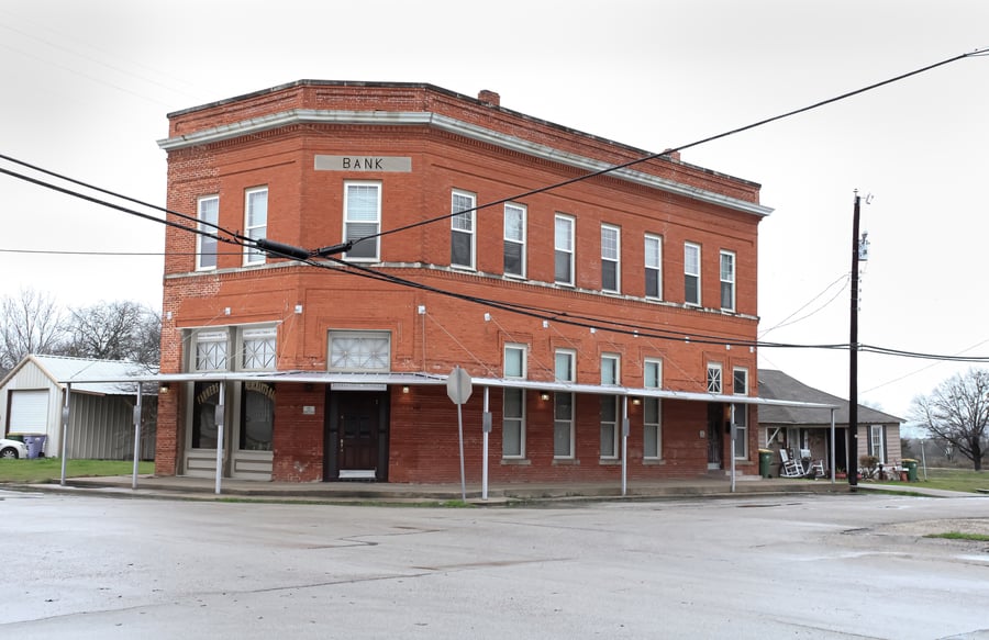 An old bank building with a corner entrance in Venus, Texas