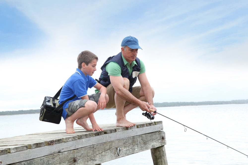 Father and son fishing in lake